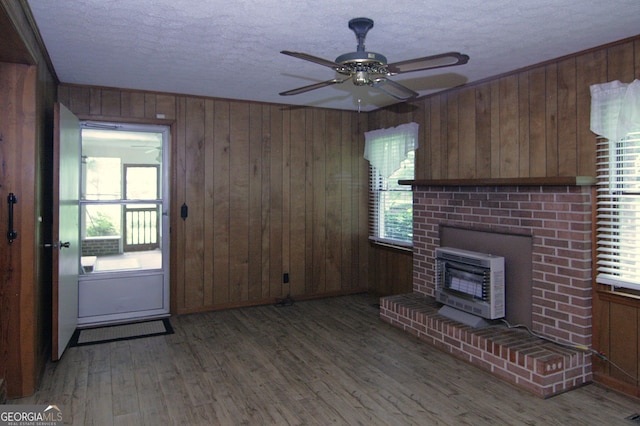 350 Laurel Ln, Lagrange, GA 30241 - unfurnished living room with heating unit, a textured ceiling, wooden walls, plenty of natural light, and wood finished floors
