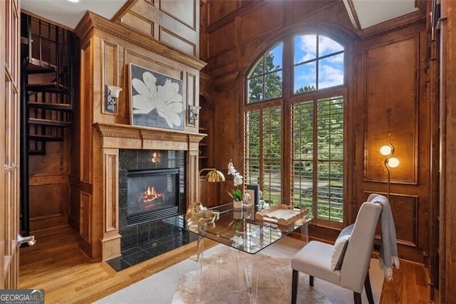 4634 Whitestone Way, Suwanee, GA 30024 - living area with wood finished floors, a tile fireplace, a towering ceiling, a decorative wall, and wooden walls