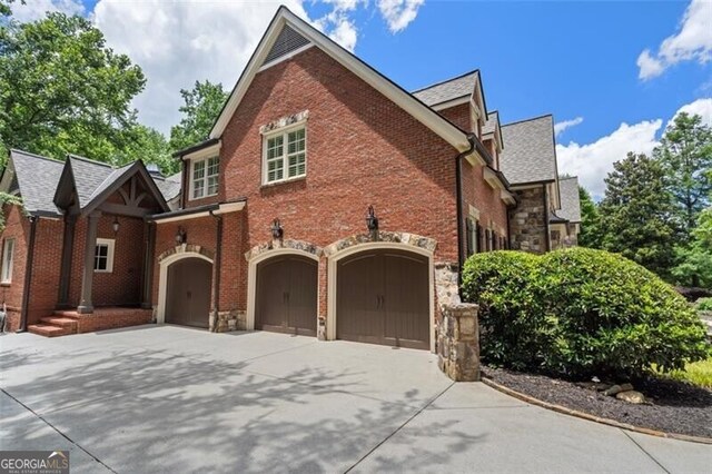 4634 Whitestone Way, Suwanee, GA 30024 - view of property exterior with stone siding, concrete driveway, a garage, and brick siding