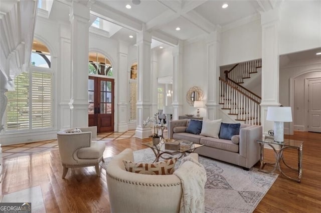 4634 Whitestone Way, Suwanee, GA 30024 - living area with ornate columns, a decorative wall, a towering ceiling, light wood-style flooring, and stairway