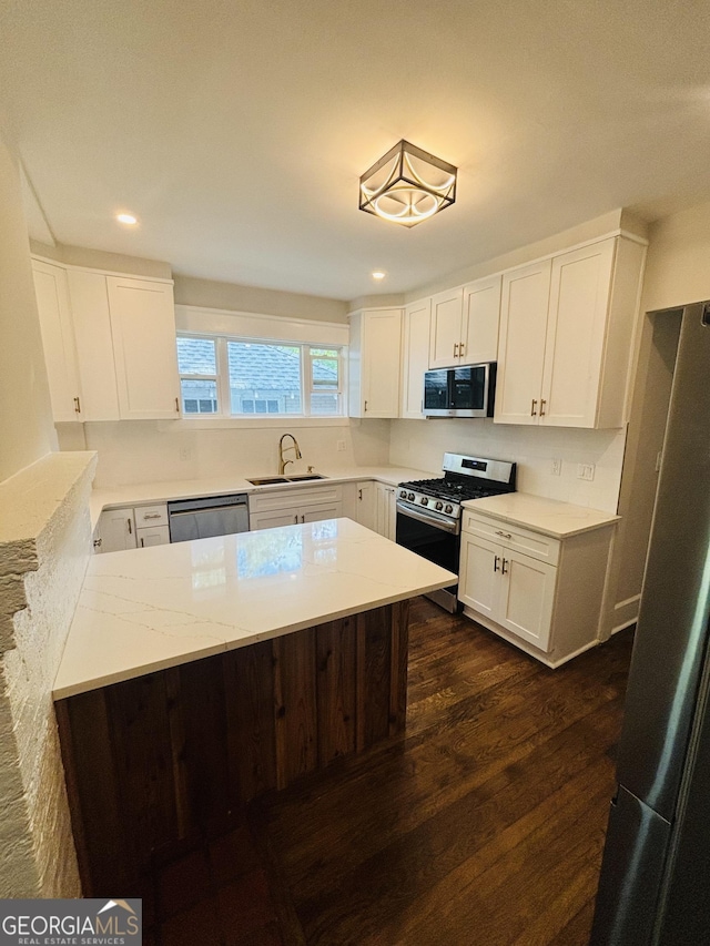 1460 Hartford Ave SW, Atlanta, GA 30310 - kitchen featuring stainless steel appliances, dark wood-type flooring, white cabinets, recessed lighting, and light stone counters