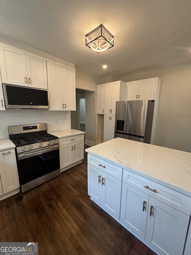 1460 Hartford Ave SW, Atlanta, GA 30310 - kitchen with stainless steel appliances, dark wood-type flooring, white cabinetry, light stone counters, and recessed lighting