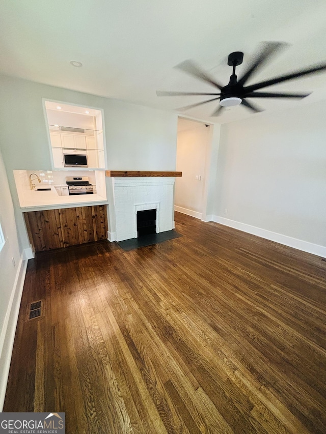 1460 Hartford Ave SW, Atlanta, GA 30310 - unfurnished living room featuring dark wood finished floors, ceiling fan, and a fireplace