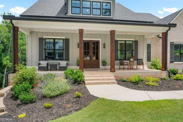 4445 Pebble Rock Dr, Cumming, GA 30041 - property entrance featuring a porch, a shingled roof, board and batten siding, and french doors