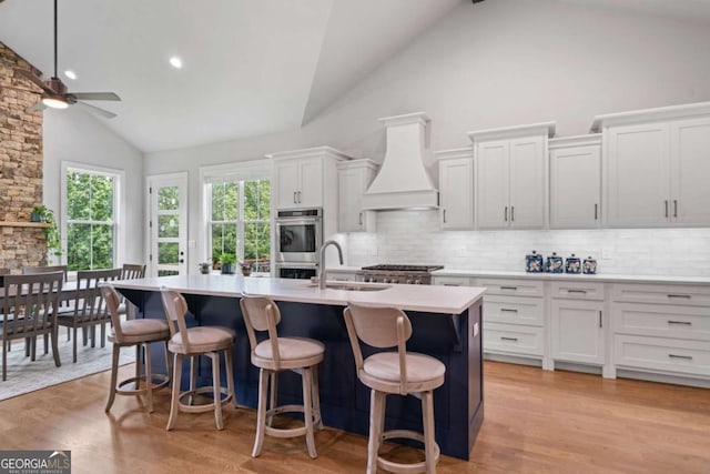 4445 Pebble Rock Dr, Cumming, GA 30041 - kitchen with premium range hood, high vaulted ceiling, a ceiling fan, tasteful backsplash, and light countertops