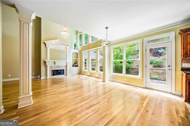 205 Camden Creek Ct, Lawrenceville, GA 30043 - unfurnished living room with decorative columns, crown molding, light wood finished floors, a fireplace with flush hearth, and a high ceiling