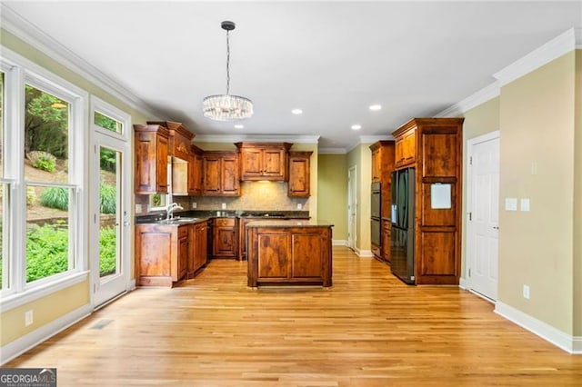 205 Camden Creek Ct, Lawrenceville, GA 30043 - kitchen with black appliances, plenty of natural light, crown molding, a chandelier, and light wood-style flooring