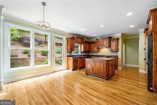 205 Camden Creek Ct, Lawrenceville, GA 30043 - kitchen with ornamental molding, light wood-style flooring, tasteful backsplash, dark countertops, and brown cabinetry