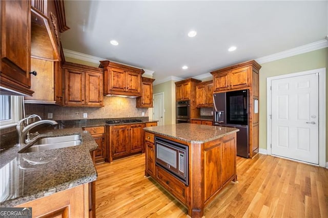 205 Camden Creek Ct, Lawrenceville, GA 30043 - kitchen featuring stainless steel appliances, crown molding, brown cabinetry, light wood-style floors, and backsplash