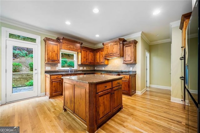 205 Camden Creek Ct, Lawrenceville, GA 30043 - kitchen with brown cabinetry, decorative backsplash, a kitchen island, ornamental molding, and recessed lighting