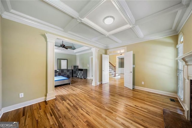 205 Camden Creek Ct, Lawrenceville, GA 30043 - unfurnished living room with coffered ceiling, decorative columns, a fireplace with flush hearth, light wood-type flooring, and stairs