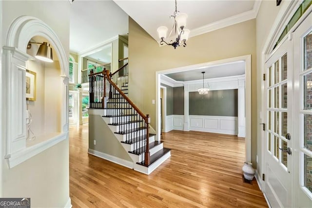 205 Camden Creek Ct, Lawrenceville, GA 30043 - entrance foyer with ornamental molding, a chandelier, wood finished floors, stairs, and a decorative wall