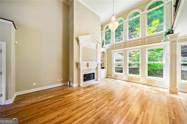 205 Camden Creek Ct, Lawrenceville, GA 30043 - unfurnished living room featuring crown molding, a high ceiling, a high end fireplace, and wood finished floors