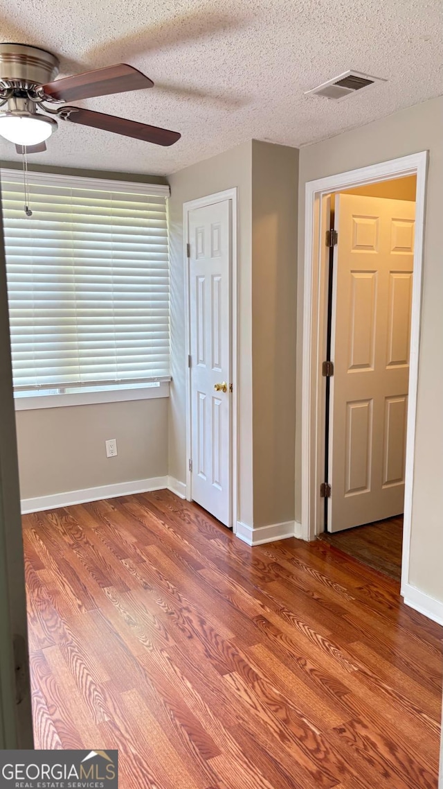 6197 Union Grove Rd, Lithia Springs, GA 30122 - unfurnished bedroom with wood finished floors, a textured ceiling, and a ceiling fan