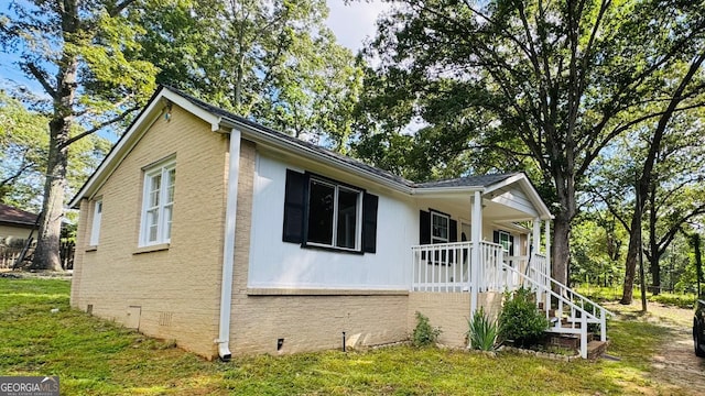 6197 Union Grove Rd, Lithia Springs, GA 30122 - view of side of home with covered porch, crawl space, brick siding, and a lawn