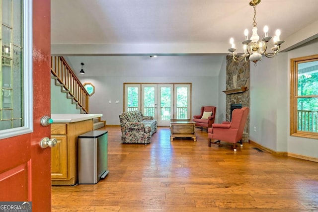 215 Souther Meadow Dr, Blairsville, GA 30512 - living area with a chandelier, beam ceiling, light wood-style floors, stairs, and a stone fireplace