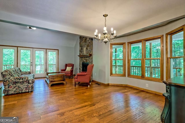 215 Souther Meadow Dr, Blairsville, GA 30512 - living area featuring a chandelier, vaulted ceiling, wood finished floors, and a stone fireplace