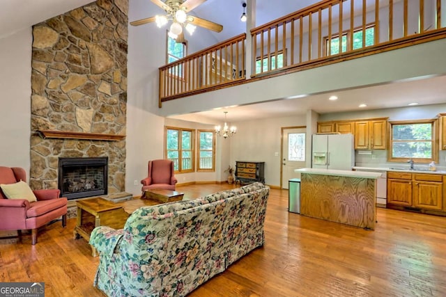 215 Souther Meadow Dr, Blairsville, GA 30512 - living room featuring a towering ceiling, light wood finished floors, a fireplace, plenty of natural light, and a ceiling fan