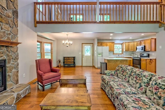 215 Souther Meadow Dr, Blairsville, GA 30512 - living area with a high ceiling, a chandelier, light wood-style flooring, and a stone fireplace