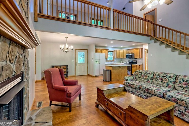215 Souther Meadow Dr, Blairsville, GA 30512 - living area featuring a high ceiling, light wood-type flooring, a fireplace, a chandelier, and ceiling fan