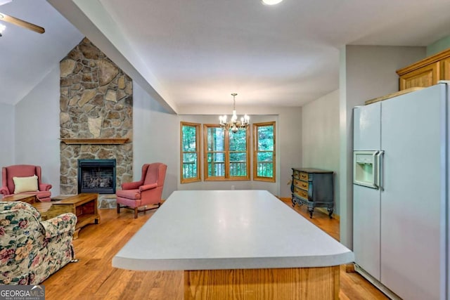 215 Souther Meadow Dr, Blairsville, GA 30512 - kitchen with white refrigerator with ice dispenser, light wood-style flooring, light countertops, a kitchen island, and a wood stove