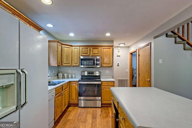 215 Souther Meadow Dr, Blairsville, GA 30512 - kitchen with stainless steel appliances, light countertops, light wood-style flooring, recessed lighting, and brown cabinets