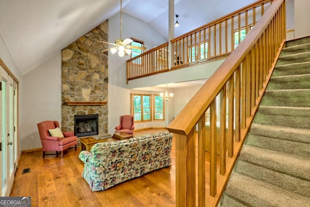 215 Souther Meadow Dr, Blairsville, GA 30512 - living area with wood finished floors, a stone fireplace, stairs, ceiling fan, and high vaulted ceiling