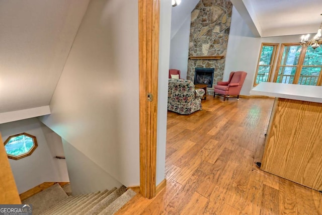 215 Souther Meadow Dr, Blairsville, GA 30512 - stairway with a fireplace, wood finished floors, lofted ceiling, and a chandelier