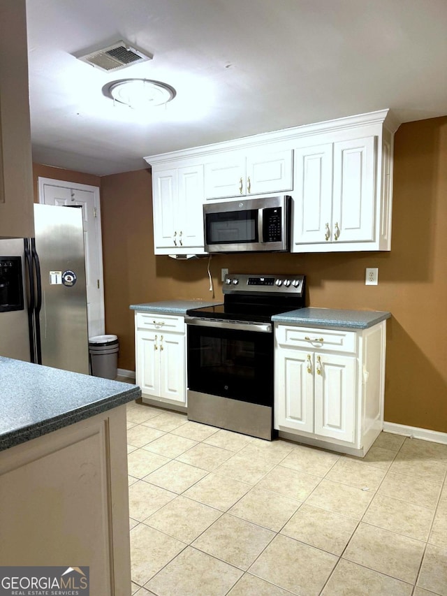 3439 Tupelo Trl, Auburn, GA 30011 - kitchen featuring appliances with stainless steel finishes, white cabinets, and light tile patterned floors