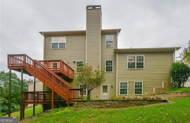 3439 Tupelo Trl, Auburn, GA 30011 - rear view of property featuring a deck, stairway, a chimney, and a lawn