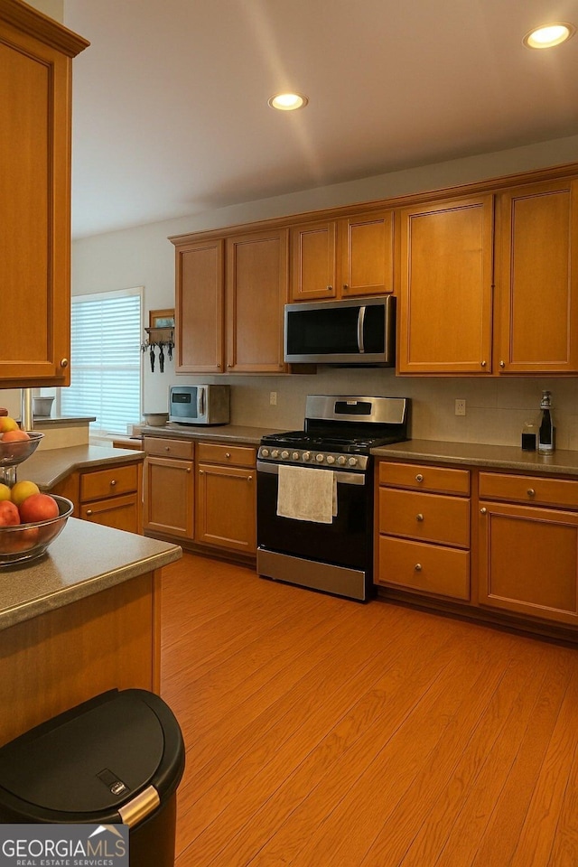 3439 Tupelo Trl, Auburn, GA 30011 - kitchen featuring appliances with stainless steel finishes, light wood-style floors, recessed lighting, and tasteful backsplash