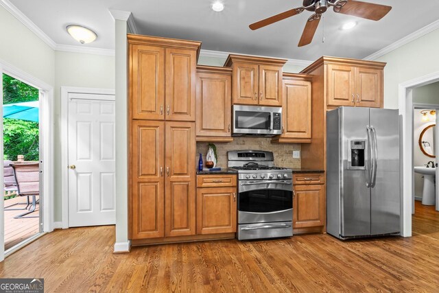 1605 Spinnaker Dr, Alpharetta, GA 30005 - kitchen with stainless steel appliances, ornamental molding, a ceiling fan, wood finished floors, and tasteful backsplash