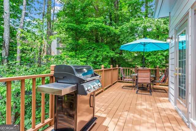 1605 Spinnaker Dr, Alpharetta, GA 30005 - wooden deck featuring outdoor dining area, a grill, and view of wooded area