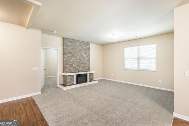 208 Flowing Meadows Dr, Kathleen, GA 31047 - unfurnished living room featuring a stone fireplace and dark wood-style floors
