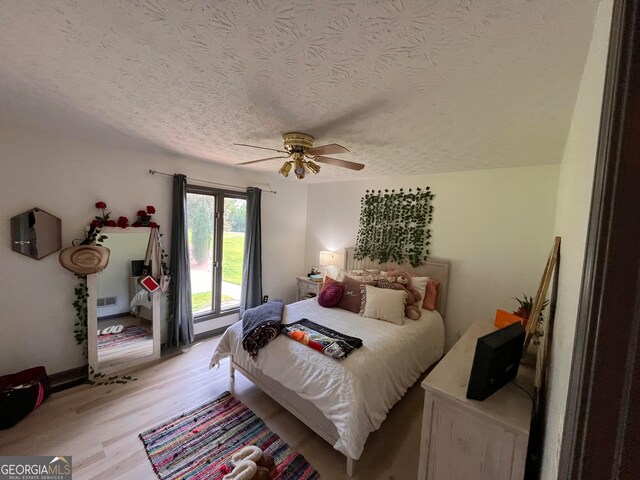 1455 River Cove Rd, Social Circle, GA 30025 - bedroom with a textured ceiling, light wood-type flooring, and ceiling fan