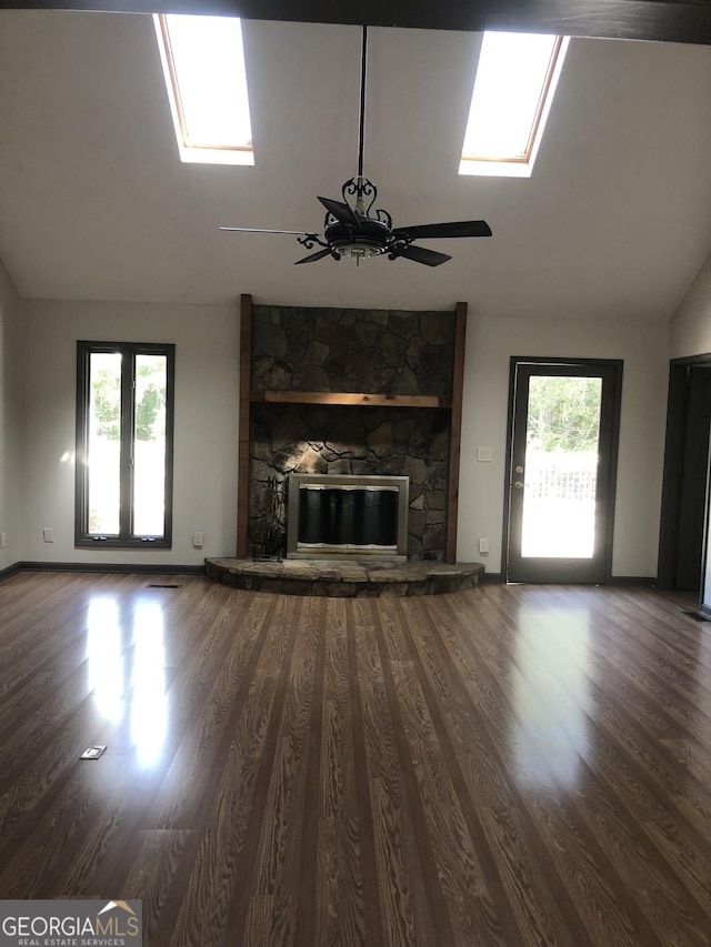 1455 River Cove Rd, Social Circle, GA 30025 - unfurnished living room featuring a skylight, ceiling fan, lofted ceiling, wood finished floors, and a fireplace