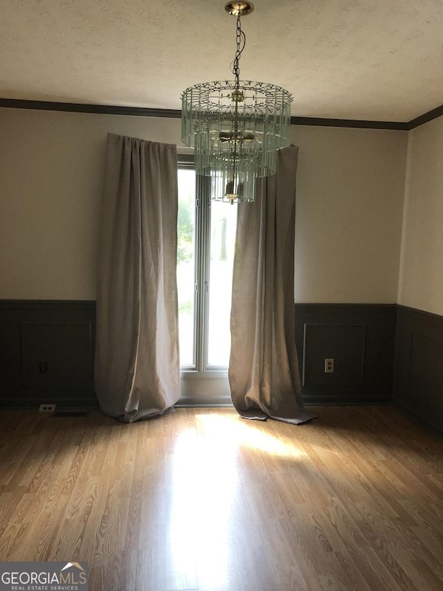 1455 River Cove Rd, Social Circle, GA 30025 - spare room featuring ornamental molding, wood finished floors, wainscoting, and a chandelier
