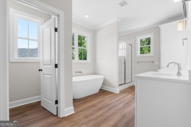 9 Honeysuckle Dr, Claxton, GA 30417 - full bathroom featuring crown molding, a shower stall, a freestanding tub, wood finished floors, and double vanity