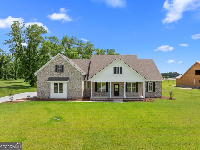 9 Honeysuckle Dr, Claxton, GA 30417 - traditional-style home with covered porch, a front lawn, brick siding, and a shingled roof