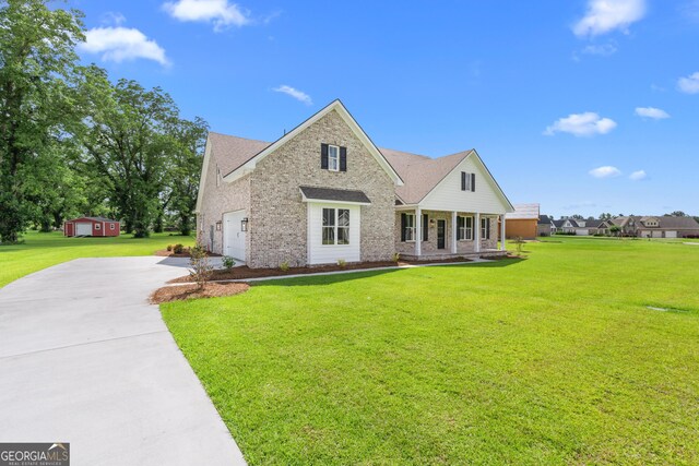 9 Honeysuckle Dr, Claxton, GA 30417 - traditional-style home with concrete driveway, brick siding, a front yard, and covered porch