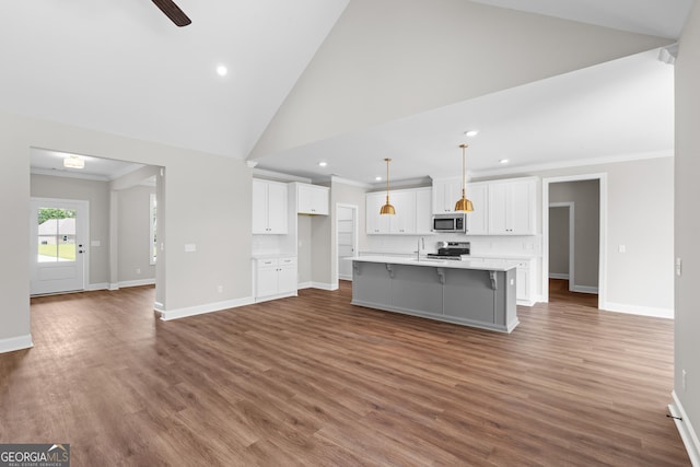 9 Honeysuckle Dr, Claxton, GA 30417 - kitchen with stainless steel microwave, stove, crown molding, recessed lighting, and white cabinetry