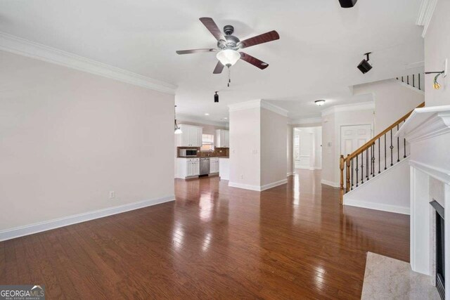 812 Autry Oak Ct, Alpharetta, GA 30022 - unfurnished living room featuring crown molding, ceiling fan, stairs, and dark wood-type flooring