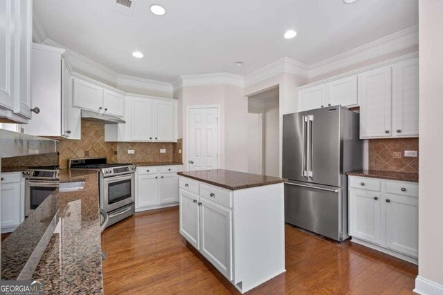 812 Autry Oak Ct, Alpharetta, GA 30022 - kitchen with stainless steel appliances, dark wood-type flooring, white cabinetry, backsplash, and dark stone counters