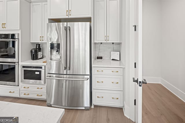 608 Southland Pass, Canton, GA 30115 - kitchen with appliances with stainless steel finishes, wood finished floors, light countertops, and tasteful backsplash