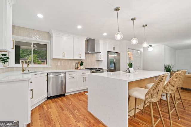 3222 Edgemont Way, Decatur, GA 30032 - kitchen featuring appliances with stainless steel finishes, wall chimney range hood, white cabinets, a kitchen island, and recessed lighting