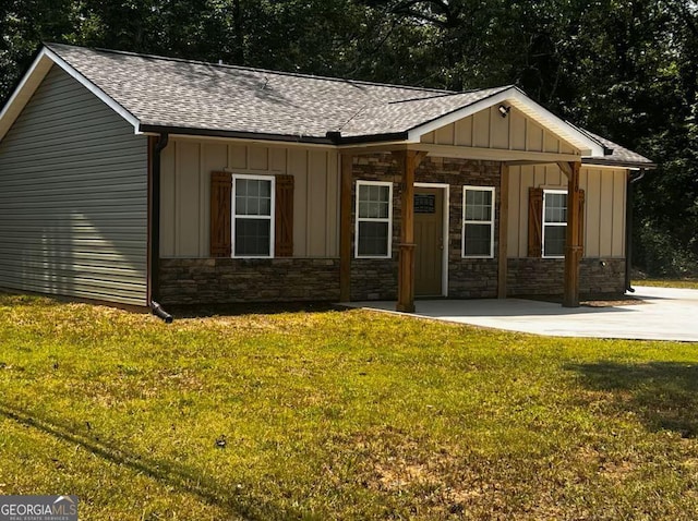 110 Williamson St SW, Rome, GA 30165 - view of front facade featuring board and batten siding, a shingled roof, stone siding, and a front yard