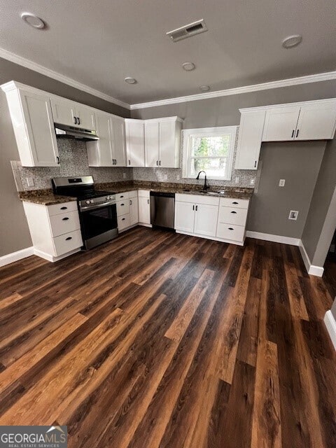 110 Williamson St SW, Rome, GA 30165 - kitchen featuring stainless steel appliances, under cabinet range hood, ornamental molding, dark countertops, and tasteful backsplash