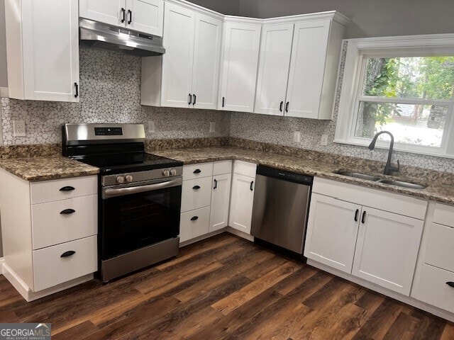 110 Williamson St SW, Rome, GA 30165 - kitchen with appliances with stainless steel finishes, under cabinet range hood, backsplash, and white cabinetry
