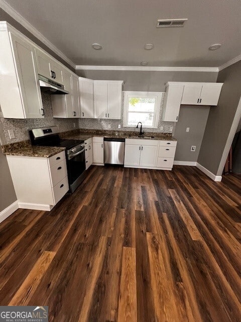 110 Williamson St SW, Rome, GA 30165 - kitchen featuring appliances with stainless steel finishes, ornamental molding, dark countertops, under cabinet range hood, and dark wood finished floors