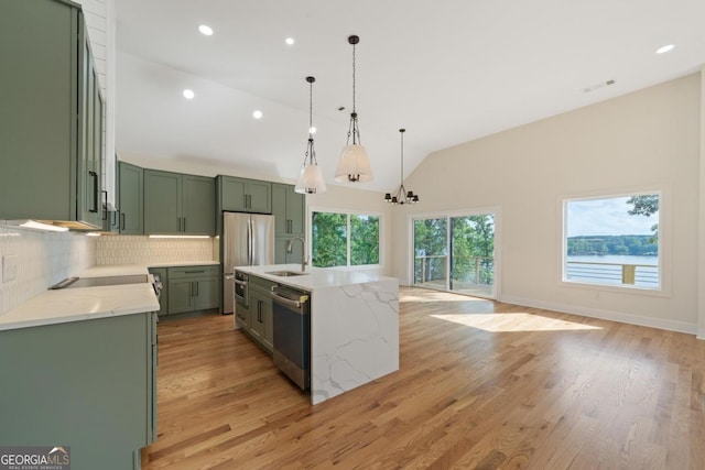631 Susan Davis Rd, Sparta, GA 31087 - kitchen with stainless steel appliances, green cabinetry, tasteful backsplash, light wood finished floors, and a chandelier